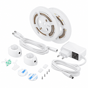 Two reels of LED strip lights, white motion sensors, cables, a power adapter, and mounting accessories on a white background.