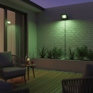 Green LED floodlight illuminating a patio wall with plants, creating a vibrant outdoor ambiance.