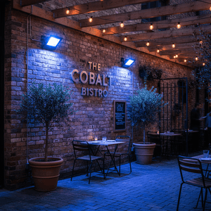 Outdoor scene featuring blue LED flood lights illuminating a bistro sign and patio area.