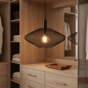 Black mesh ceiling light hanging above a wooden dresser with neatly folded towels and a decorative tray.