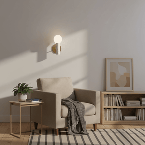 Ollie White Marble Wall Light mounted beside a cozy armchair, casting a soft glow in a stylish living room setting.