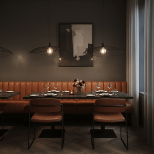 Stylish dining area featuring three black pendant lights above a wooden table with leather seating.