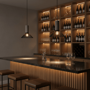 Stylish pendant lights above a bar counter with wooden shelves and wine bottles in a modern setting.