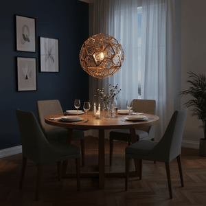 Geometric copper pendant light hanging above a wooden dining table set for dinner, with candles and decor.