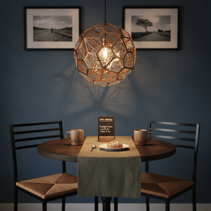 Alberta Geo Copper Pendant Light hanging above a small dining table set for breakfast.