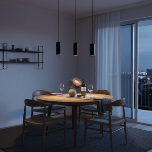 Three Solo Round Aluminium Pendants hang over a wooden dining table, creating a warm ambiance.