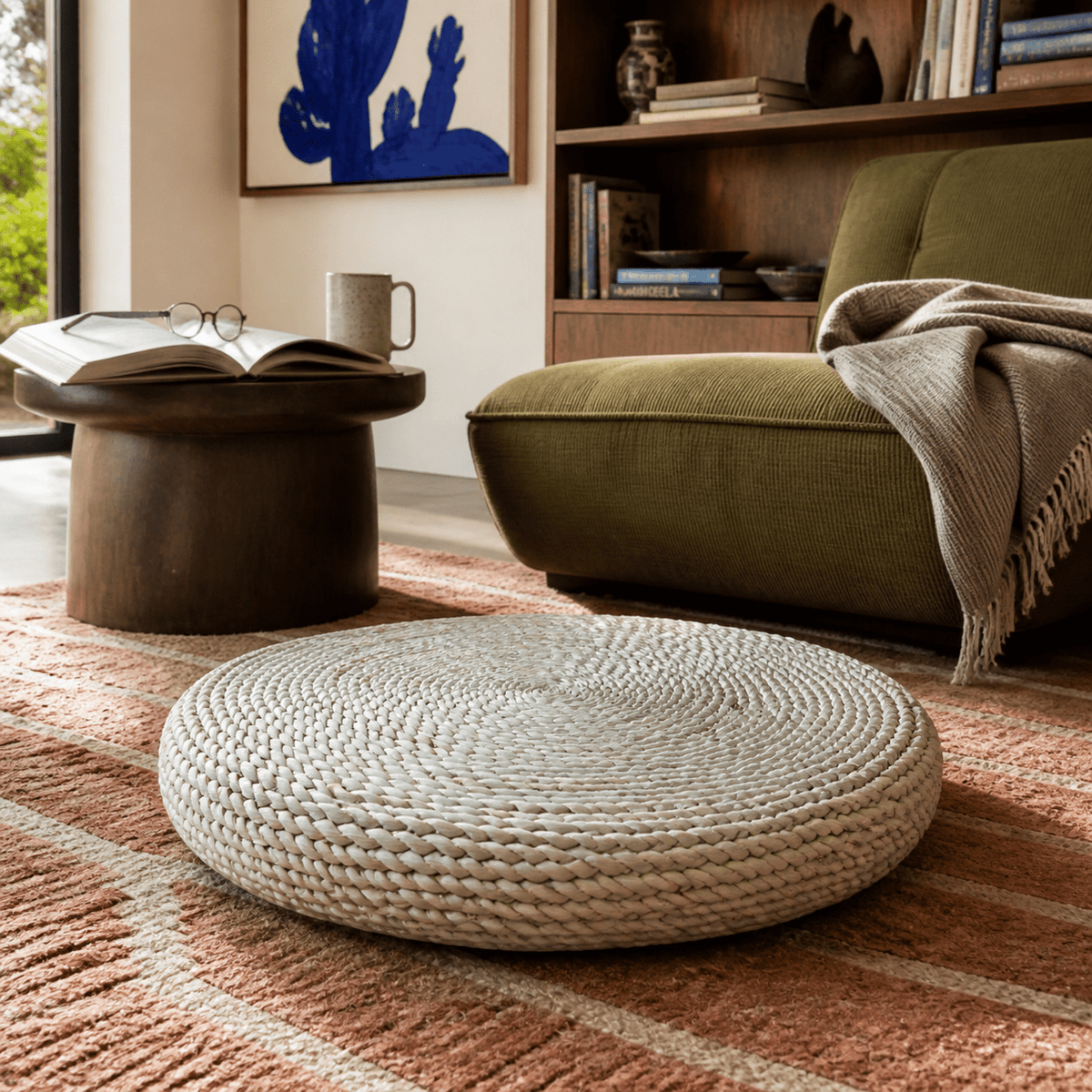 Round woven natural floor cushion in a lived-in South African interior, lifestyle scene 1