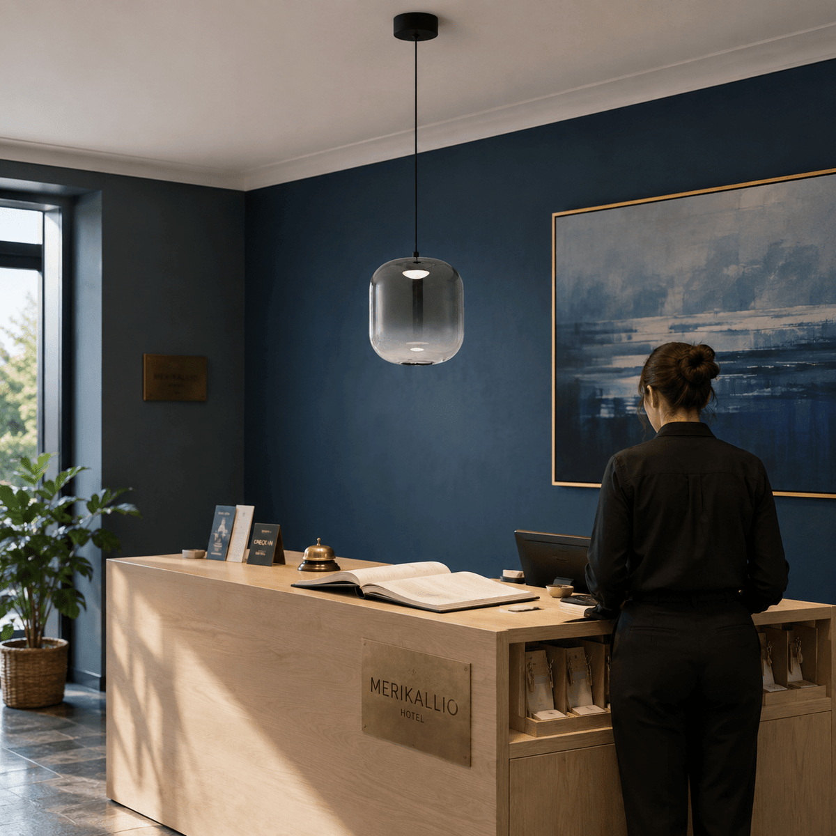 Black smoky-glass LED pendant light above a boutique hotel reception desk