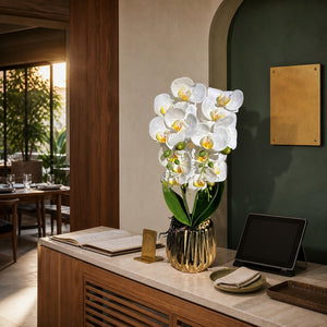 Artificial white Phalaenopsis orchid in reflective gold fluted pot on a boutique hotel host stand