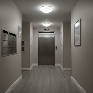 A well-lit indoor hallway featuring flush ceiling lights, an elevator, and mailboxes.