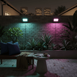 Outdoor scene featuring a 100W RGBW LED floodlight illuminating a garden wall with vibrant colors.