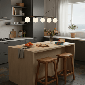 Linear 5-light black pendant light above a wooden kitchen island with fruit and flowers.