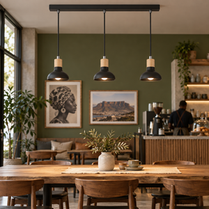 Three-light black pendant with wood collars above a café table
